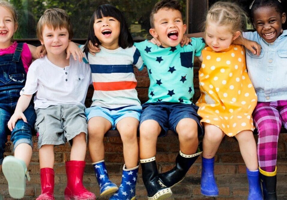 A group of children sitting on the ground together.